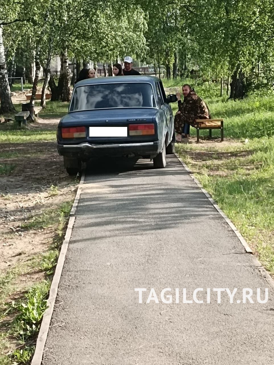 Автомобили заезжают в парк поселка Первомайский